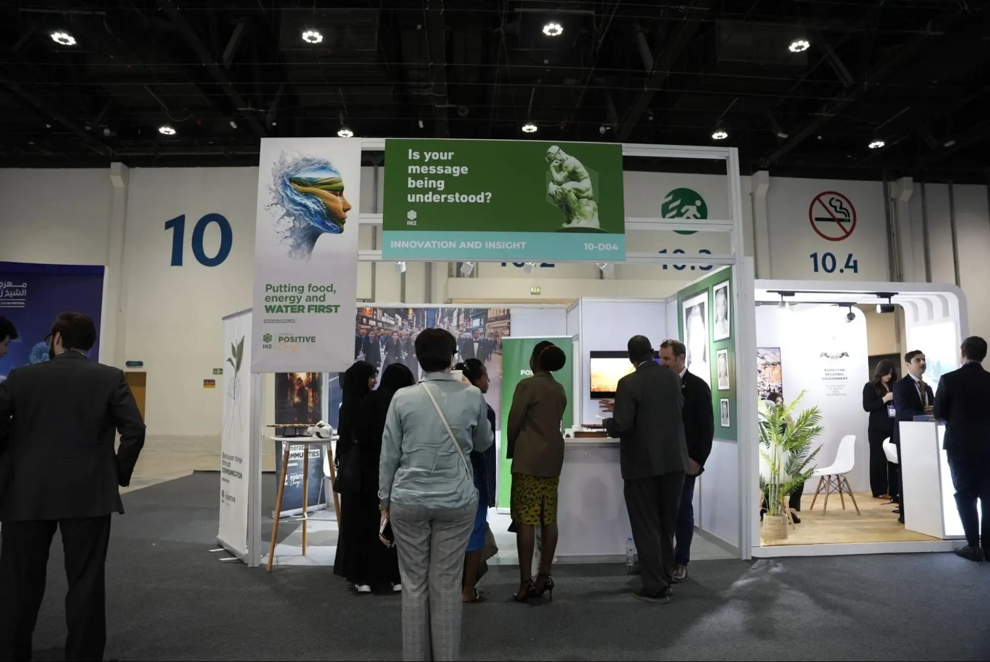 “Attendees visit the IN2 booth at a conference”